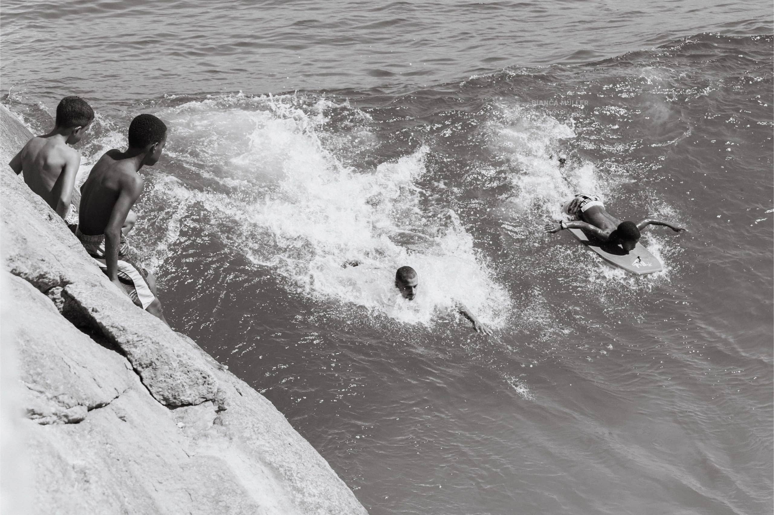 Two Boys Watching Friends Bodysurf